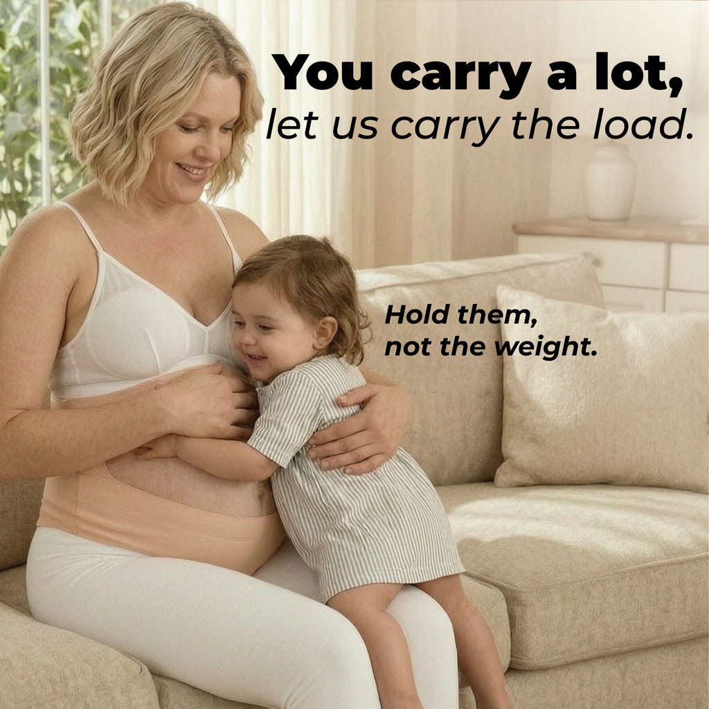Mother wearing the belly band while holding her toddler on the sofa