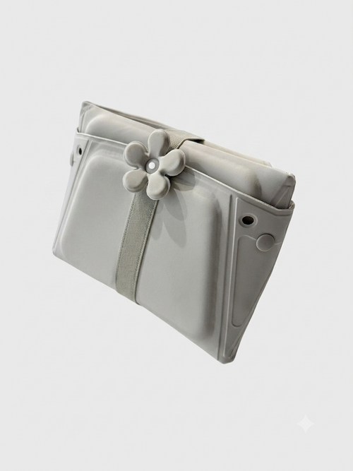 The Momnagi sink bather in the grey colourway, folded flat with its travel strap fastened